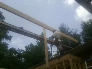Carpenter setting a ridge beam over a new addition frame — Ice Dam Removal by Roofing Brothers in Culdesac