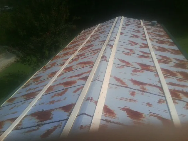 Rusted metal roof panels with new wood purlins before replacement — Storm Damage Roof Repair in Culdesac by Roofing Brothers