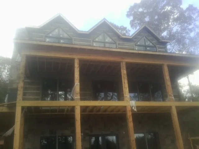 Dormers and porch framing on a large log home under construction — Roof Coating work by our crew in Culdesac