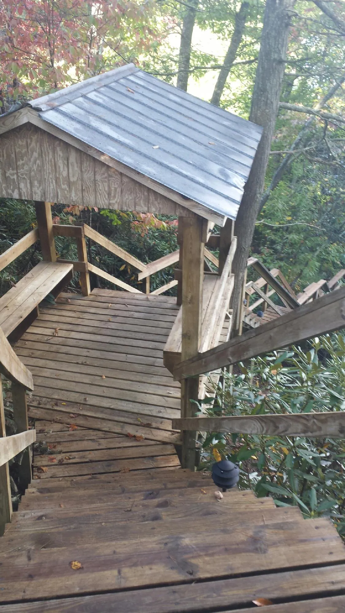 Metal roofed shelter over wooden steps on a wooded walkway — Skylight Repair & Installation work by our crew in Culdesac